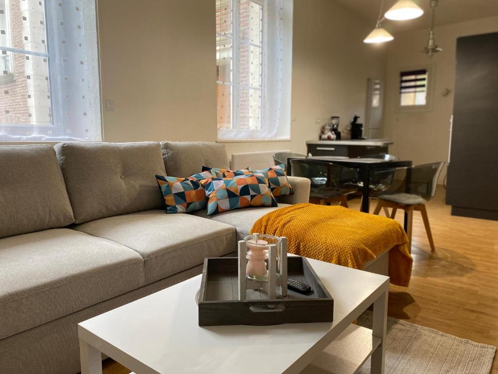 a living room with a couch and a table at Appartement coeur centre ville in Noyon