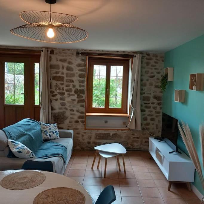 een woonkamer met een bank en een tafel bij gîte le petit roussel in Putanges
