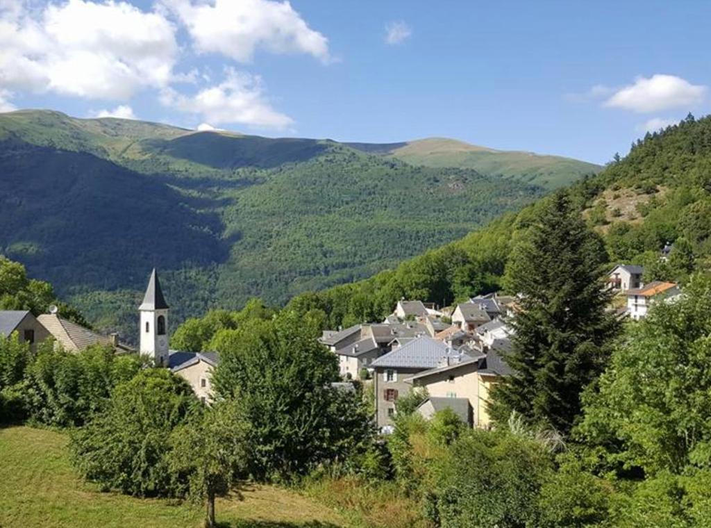 un petit village dans les montagnes avec une église dans l'établissement Maison à la montagne, à Sem