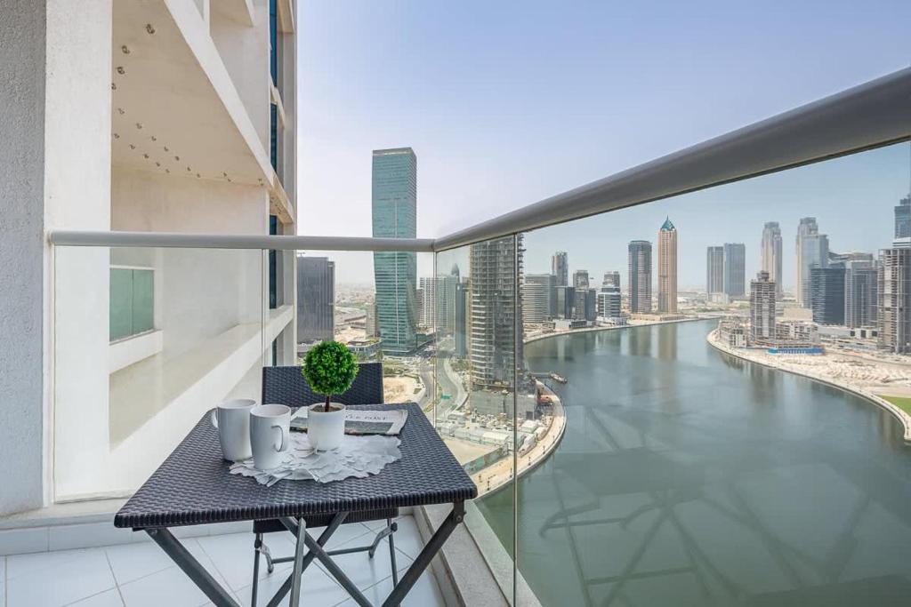 einen Tisch auf einem Balkon mit Flussblick in der Unterkunft Frank Porter - Prive A in Dubai