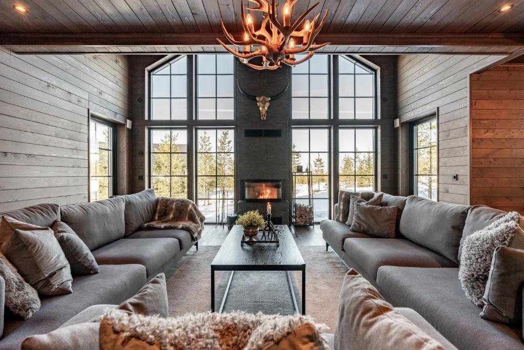 uma sala de estar com sofás e uma lareira em Idre Sky Mountain Lodge- Ski in Ski out em Idre