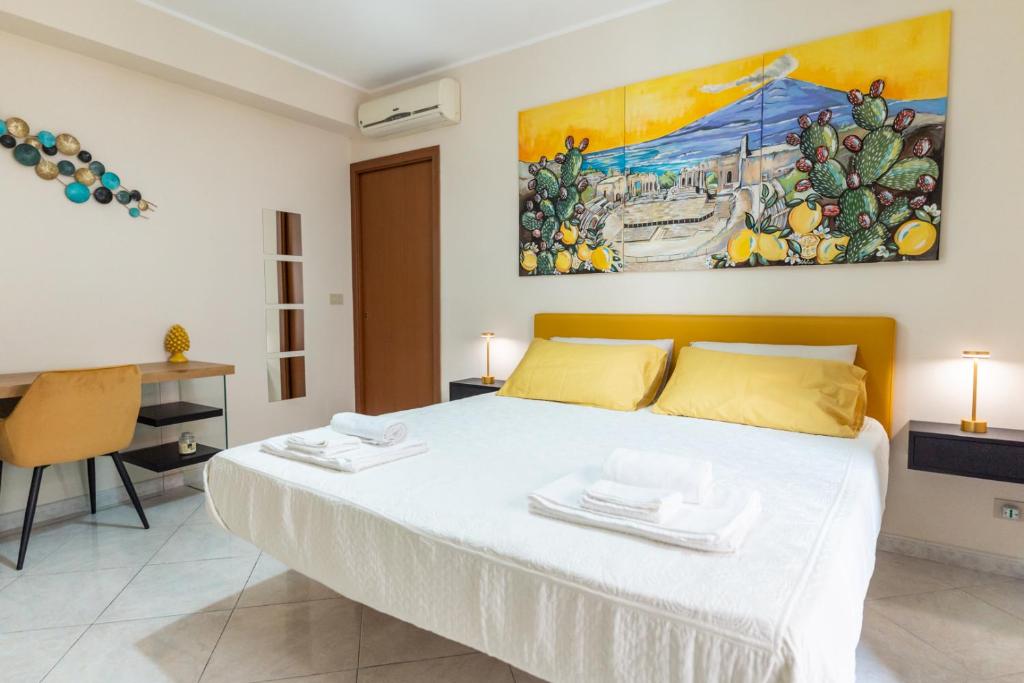 een slaapkamer met een bed en een schilderij aan de muur bij Appartamento Georgiana in Taormina