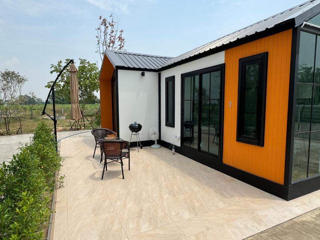 uma casa laranja e branca com um pátio em „Mayuree“ - Homestay em Kranuan