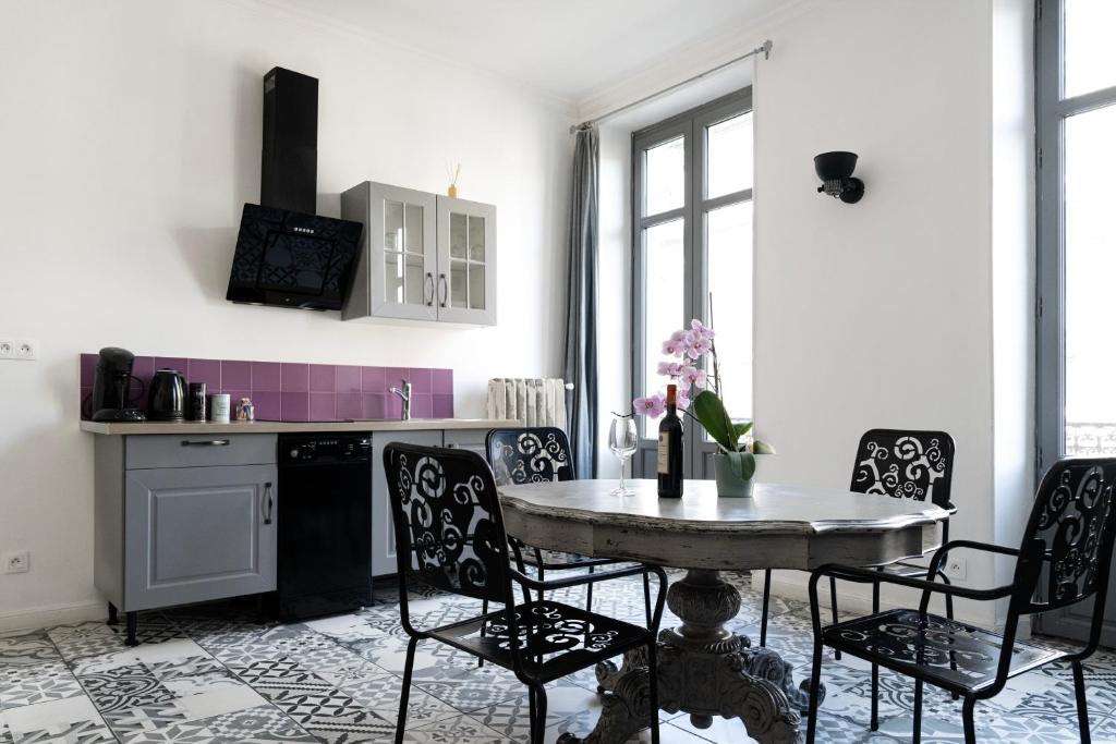 una cucina con tavolo e sedie in una stanza di Carcassonne Bastide a Carcassonne