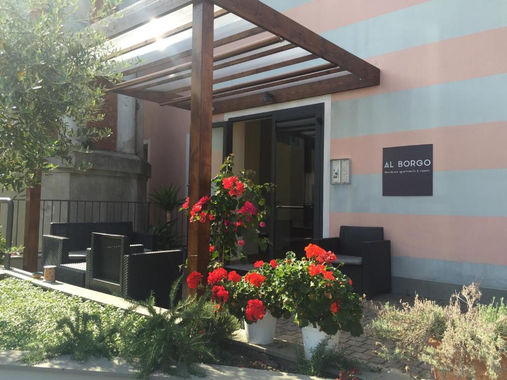 サルザーナにあるAl Borgoの椅子と花の目の前の建物