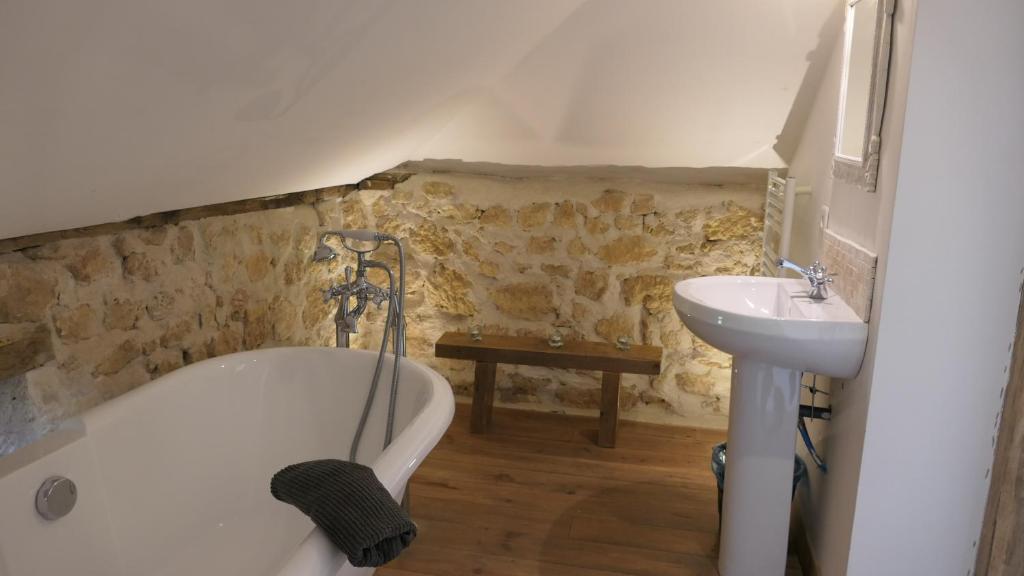 a bathroom with a bath tub and a sink at Le Moulin du Clapier La Banette in Sorges