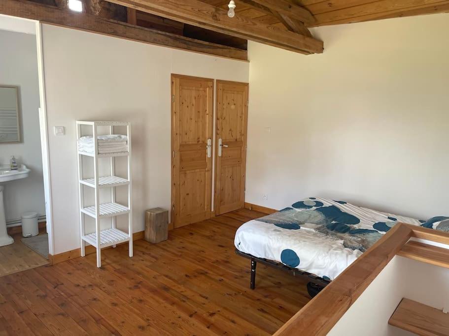 una camera da letto con un letto e un pavimento in legno di Maison en pleine nature a Saint-Maurice-en-Gourgois