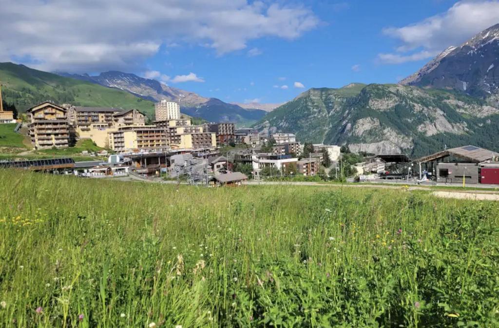 une ville dans un champ avec des montagnes en arrière-plan dans l'établissement Appartement avec vue T2 7pl 55m2 Orcières Merlette, à Orcières