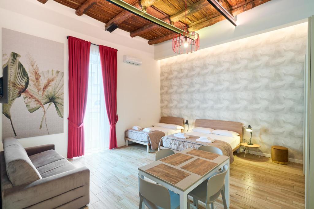 a living room with two beds and a table at Toto e Peppino luxury rooms in Naples