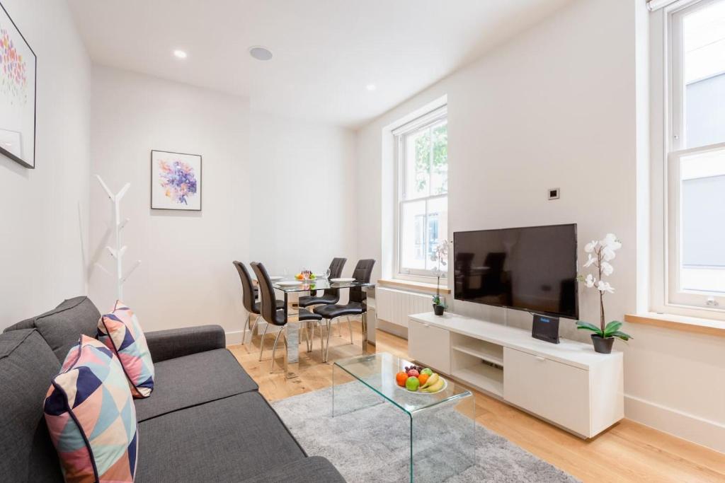 a living room with a couch and a tv at Soho - Central London - CityApartmentStay in London