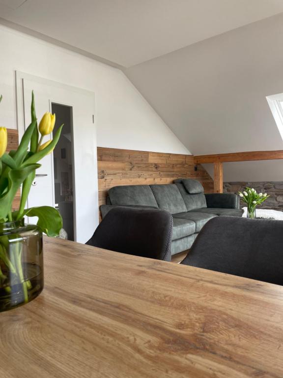 uma sala de estar com uma mesa e um sofá em Mellie`s Ferienwohnung Willingen em Willingen