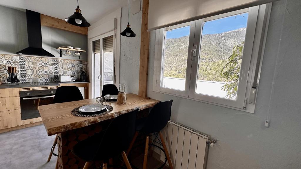 uma cozinha com um balcão com cadeiras e uma janela em Gredos Starlight House - AURIGA em Mijares