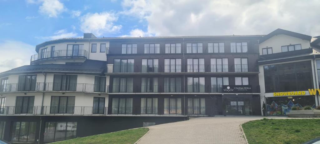 a large building with a lot of windows at Czarna Perła Apartamenty Czarna Góra 103 in Sienna