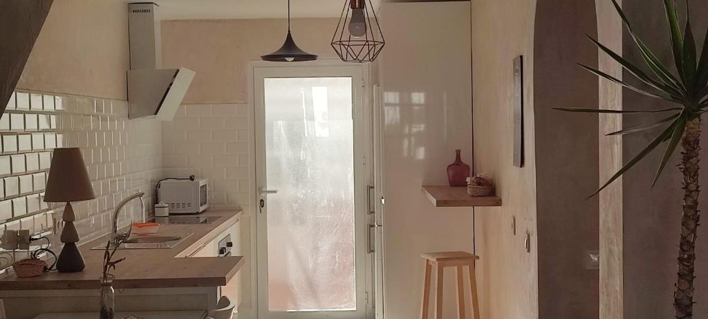 uma cozinha com uma porta que dá acesso a uma cozinha com um lavatório em CASA CON TERRAZA, BARBACOA y WIFI PARA 7 PERSONAS em Ayamonte
