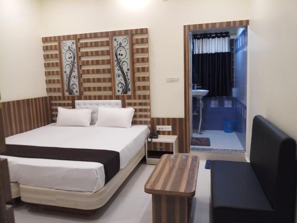 a bedroom with a bed and a table and a television at HOTEL R K RESIDENCY MUZAFFARPUR in Muzaffarpur