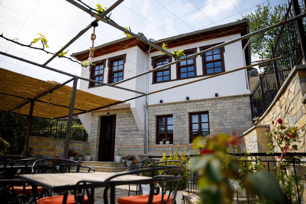 eine Terrasse mit Tischen und Stühlen vor einem Gebäude in der Unterkunft Hotel Pashai in Gjirokastër