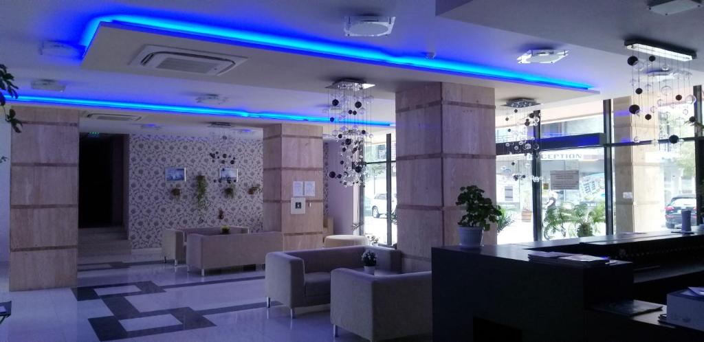 un vestíbulo con sofás y luces azules en un edificio en Апартамент Поморие плажен комплекс, en Pomorie