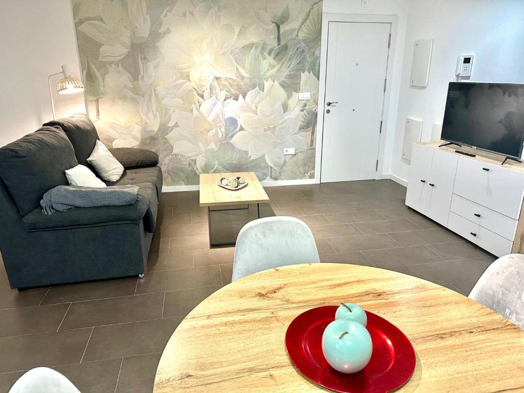 una sala de estar con una mesa y un sofá en Coello31 - Apartamento céntrico y tranquilo, con piscina y parking, en Jaén