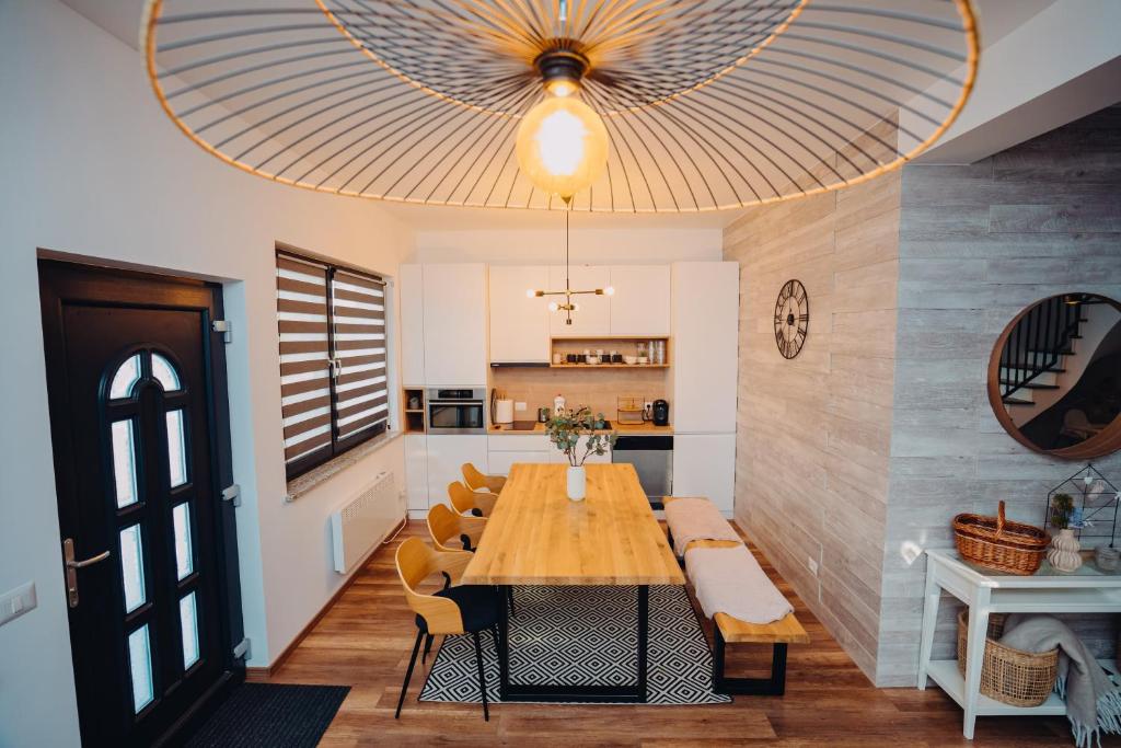 Un comedor con una gran mesa y sillas de madera. en NorthSpot Cabin, en Horodnic de Sus
