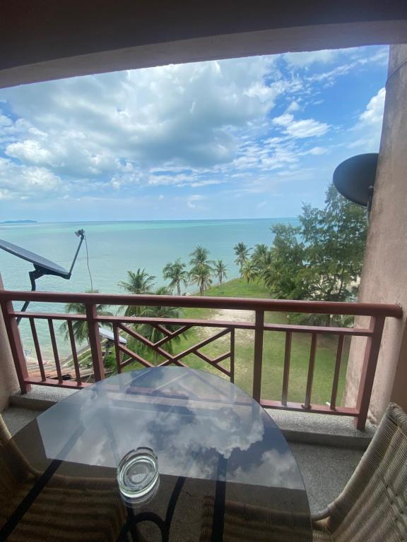 een tafel op een balkon met uitzicht op de oceaan bij Lovly Couple Sea View w Netflix in Port Dickson