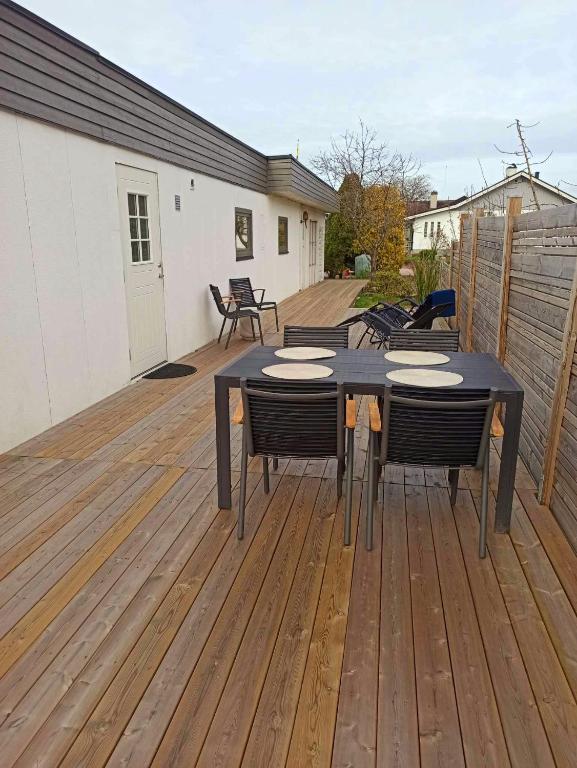un patio con mesa y sillas en una terraza en Ängelholm boende, en Ängelholm