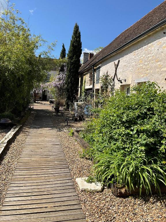 une passerelle en bois dans un jardin à côté d'un bâtiment dans l'établissement La Treille, à Lainsecq
