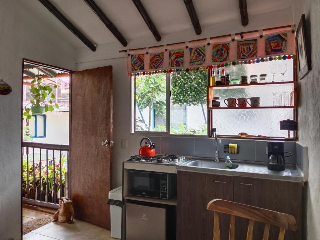 a kitchen with a sink and a microwave at Apartaestudios La Baranda in Salento