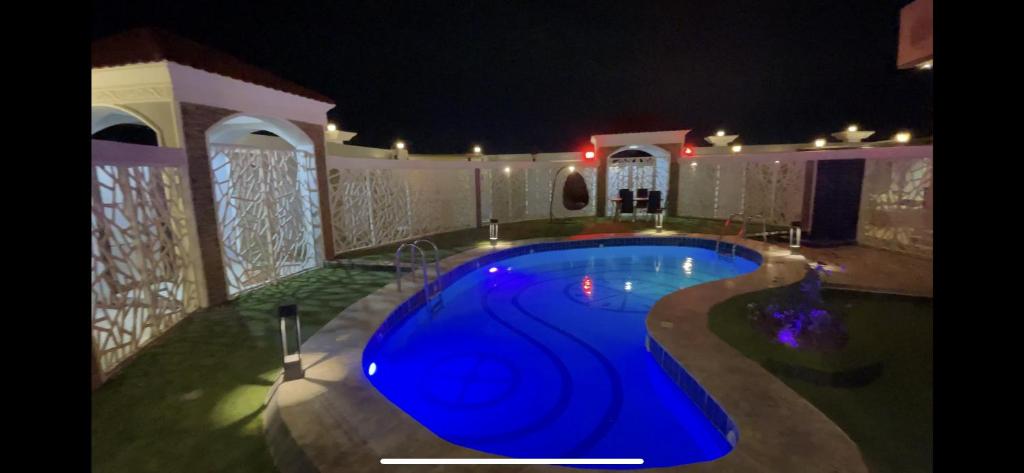 a swimming pool in a house at night at منتجع واستراحة اليخت in Khalij Salman