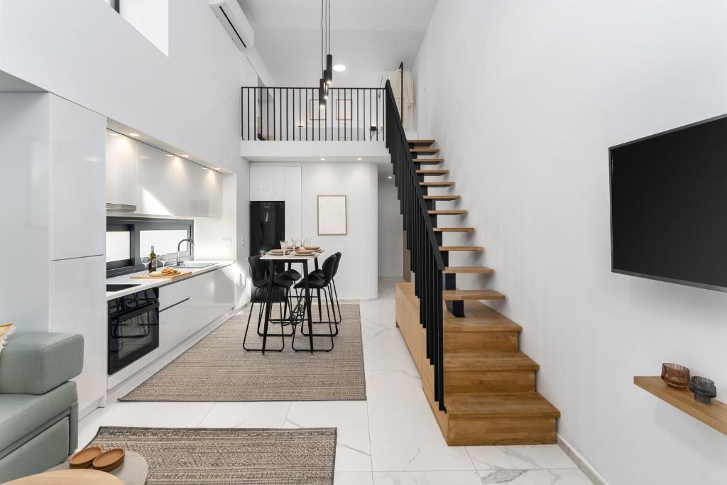 un soggiorno con scala e una cucina con tavolo di Aelia Elegant Apartments a Kalamáta