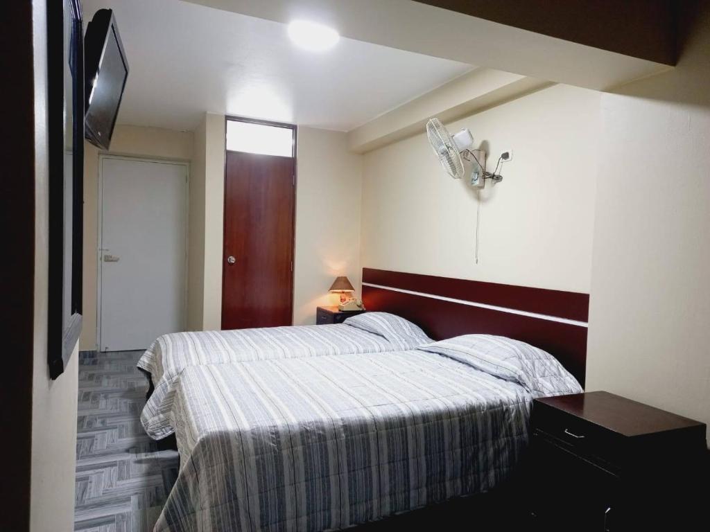 a bedroom with two beds and a television in it at Hotel Perú Pacífico in Lima