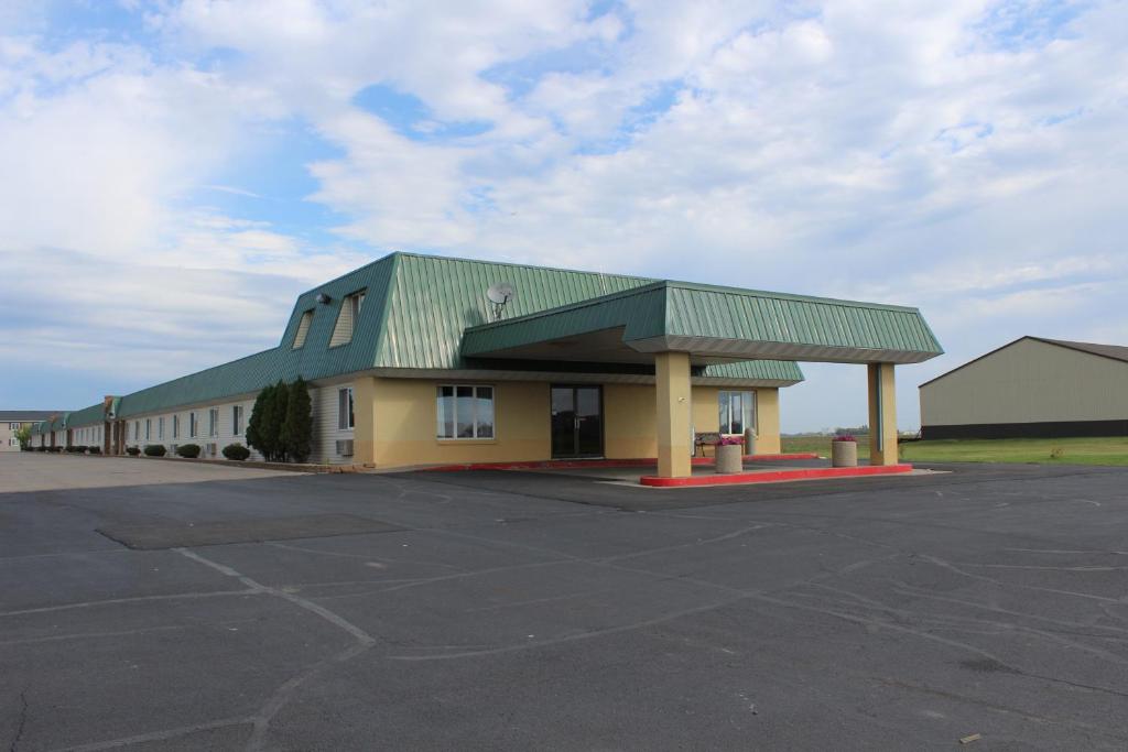 un edificio con tetto verde e un parcheggio di East Grand Inn a East Grand Forks