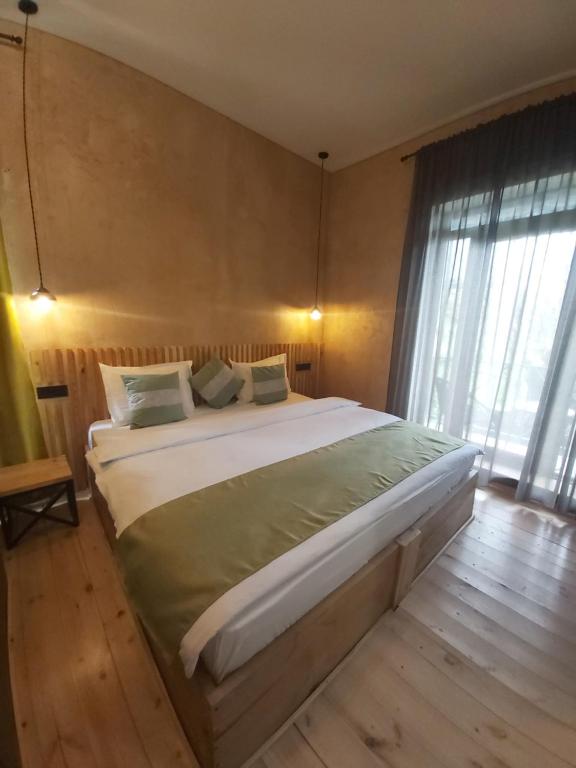 a bedroom with a large bed and a large window at Valley Park Dilijan in Dilijan