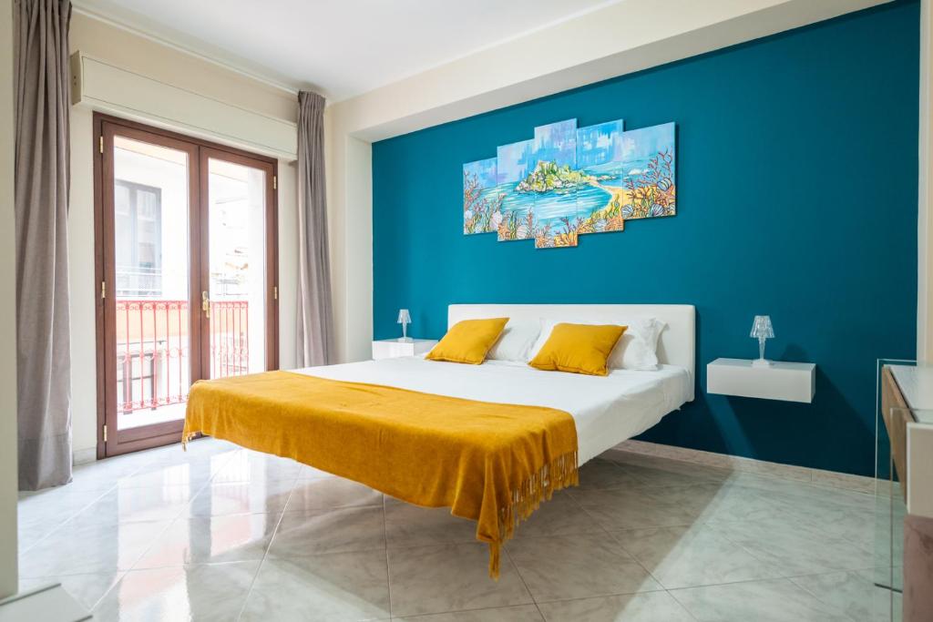 a bedroom with a large bed with a blue wall at Appartamento Nicoletta in Taormina