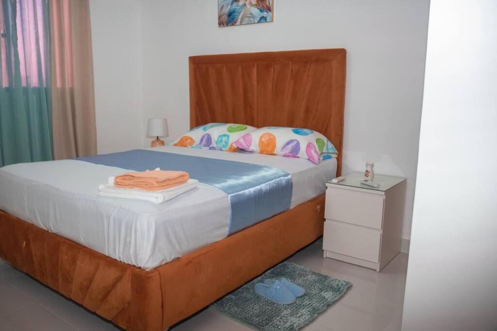 ein Schlafzimmer mit einem Bett mit einem Kopfteil aus Holz in der Unterkunft LES RÉSIDENCES ROYAL LUXE 3a in Cancino