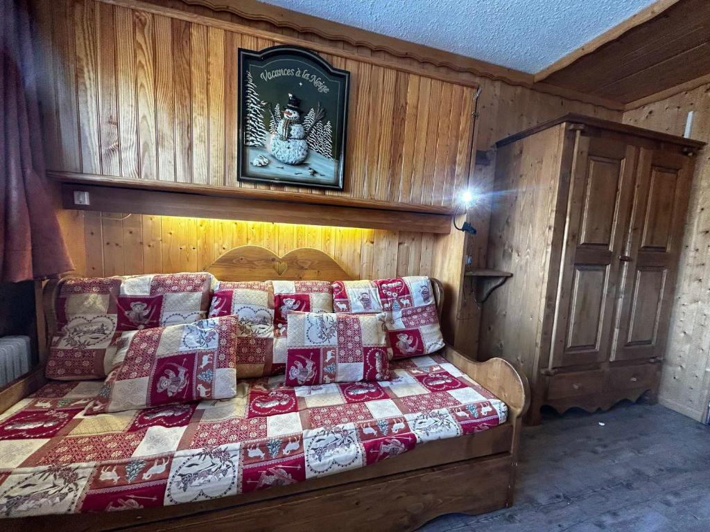 une chambre avec un lit avec une couette dessus dans l'établissement Studio cosy pour 2 personnes, skis aux pieds, Les Menuires - FR-1-452-121, aux Menuires