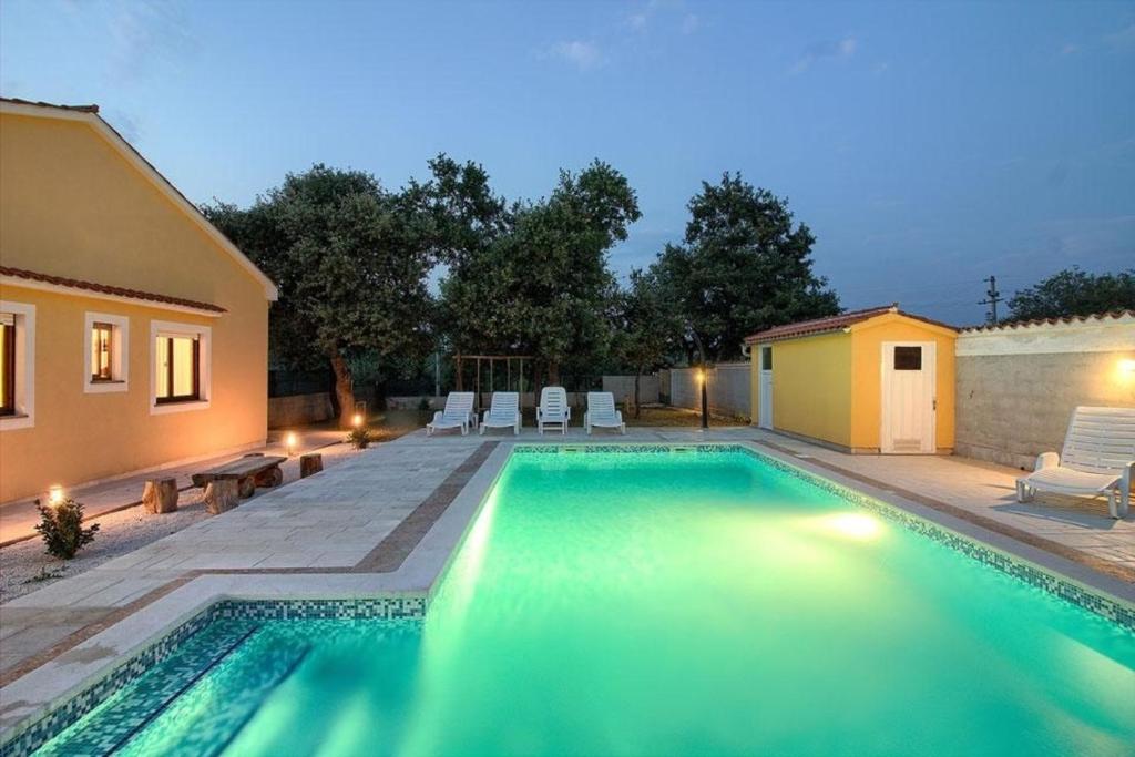 a swimming pool in the backyard of a house at Ferienhaus mit Privatpool für 10 Personen ca 130 qm in Paradiž bei Vodnjan, Istrien Südküste von Istrien in Juršići