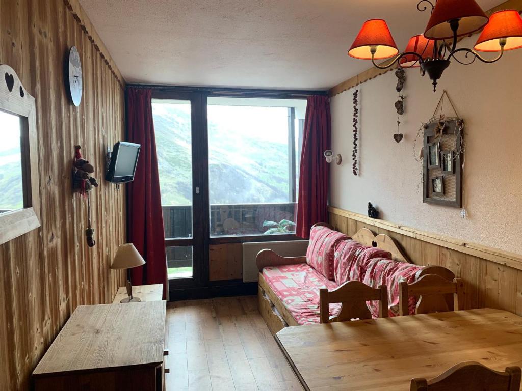 a living room with a couch and a table at Charmant studio cabine aux Ménuires, pied des pistes, balcon, animaux permis, accès télébenne gratuit - FR-1-452-43 in Les Menuires