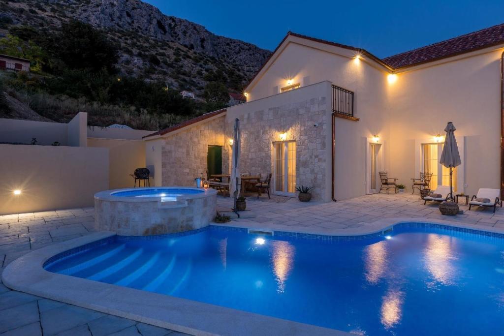eine Villa mit einem Pool in der Nacht in der Unterkunft Ferienhaus für 8 Personen und 2 Kinder in Podstrana, Dalmatien Mitteldalmatien in Podstrana