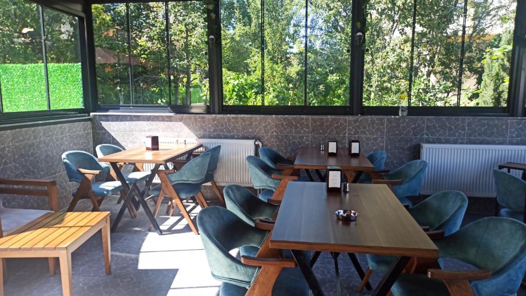 a row of tables and chairs in a restaurant with windows at ORDU KONUK EVLERİ in Akçatepe