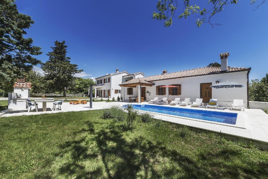 a house with a swimming pool and a yard at Ferienhaus mit Privatpool für 12 Personen ca 254 qm in Labin, Istrien Bucht von Raša in Labin