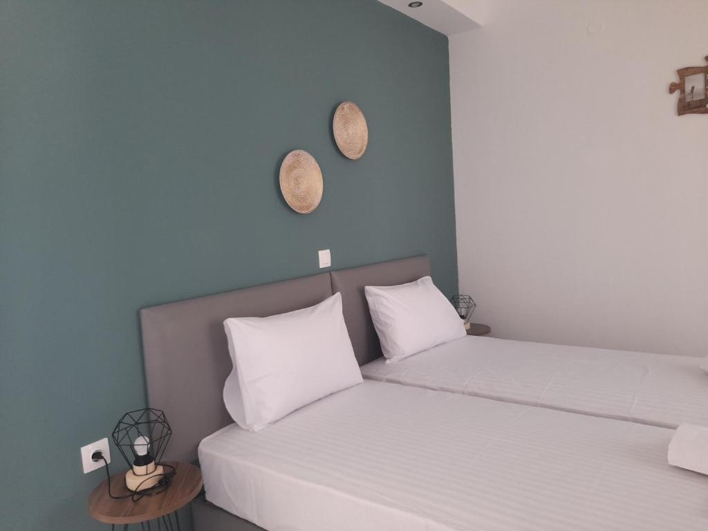 two beds with white pillows in a room with blue walls at Euphoria ComplexB in Kavos