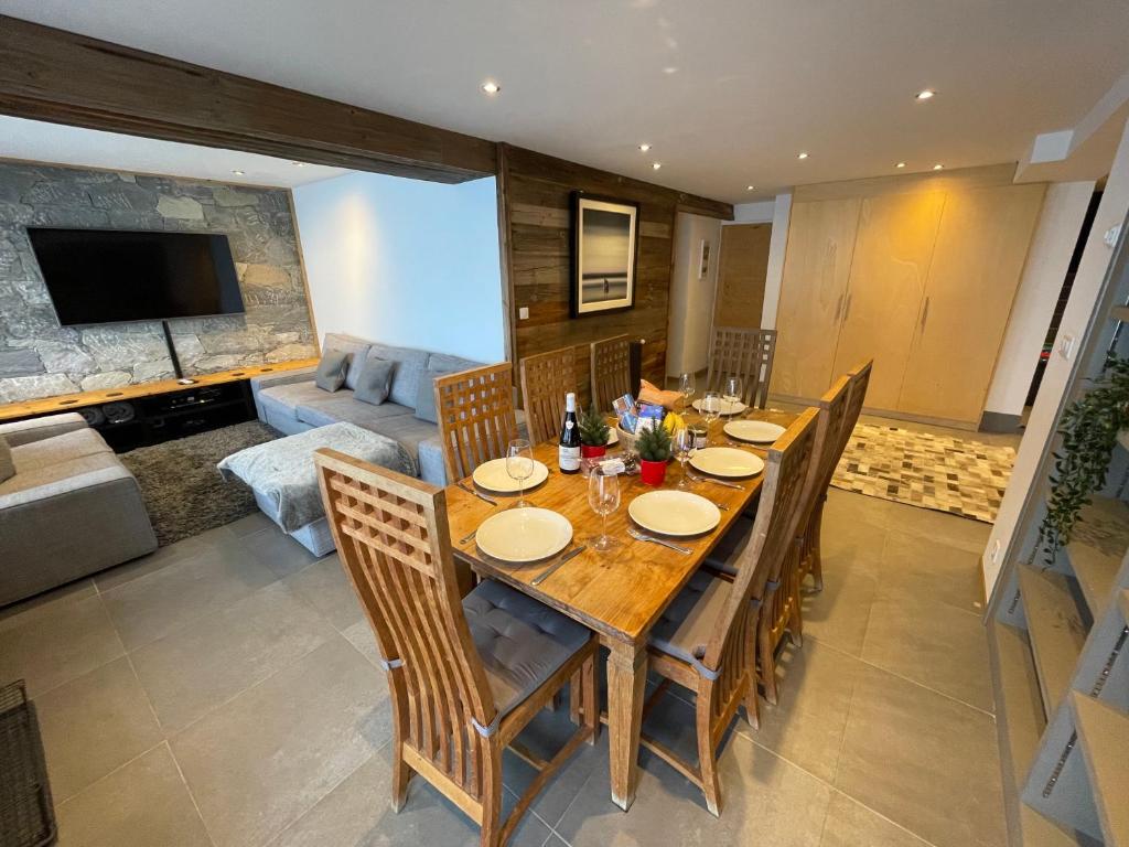 a dining room with a wooden table and chairs at Ski in-Ski out! Spacious & Stylish Apartment for 8 in the heart of Lavachet in Tignes