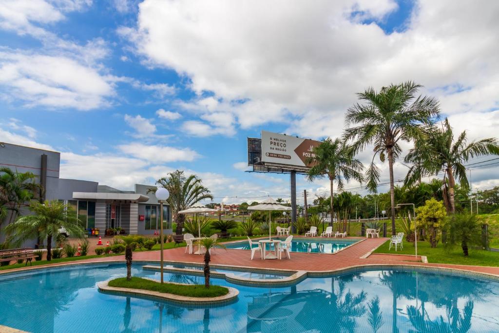 a pool at a resort with palm trees at Foz Budget Hotel in Foz do Iguaçu