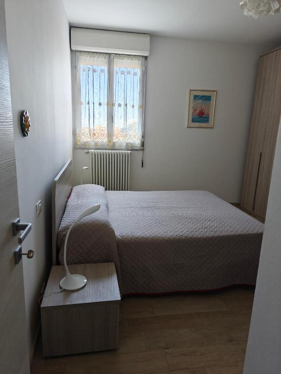 a bedroom with a bed and a lamp on a table at Appartamento donatello in Imola