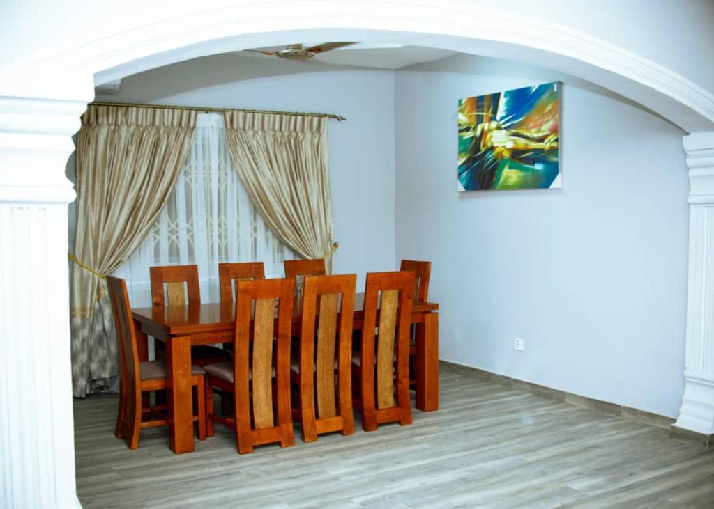 comedor con mesa de madera y sillas en Estben guesthouse, en Kwabenyan