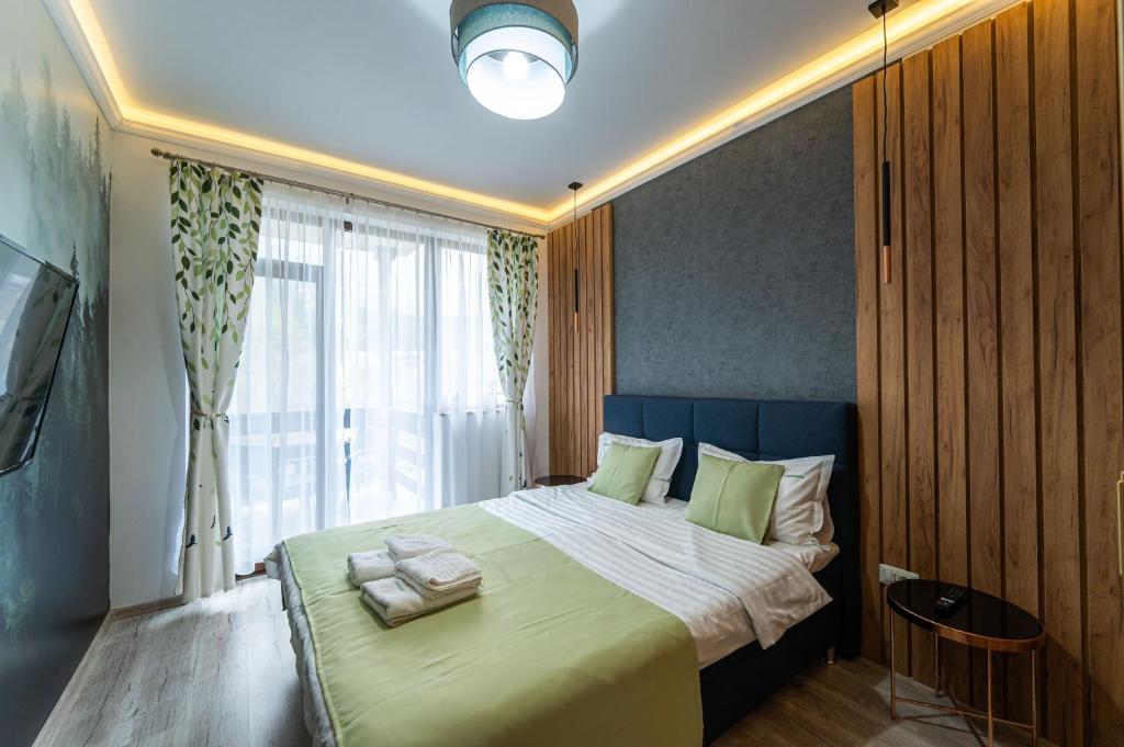a bedroom with a large bed with a large window at Cross Caraiman View 2 in Buşteni