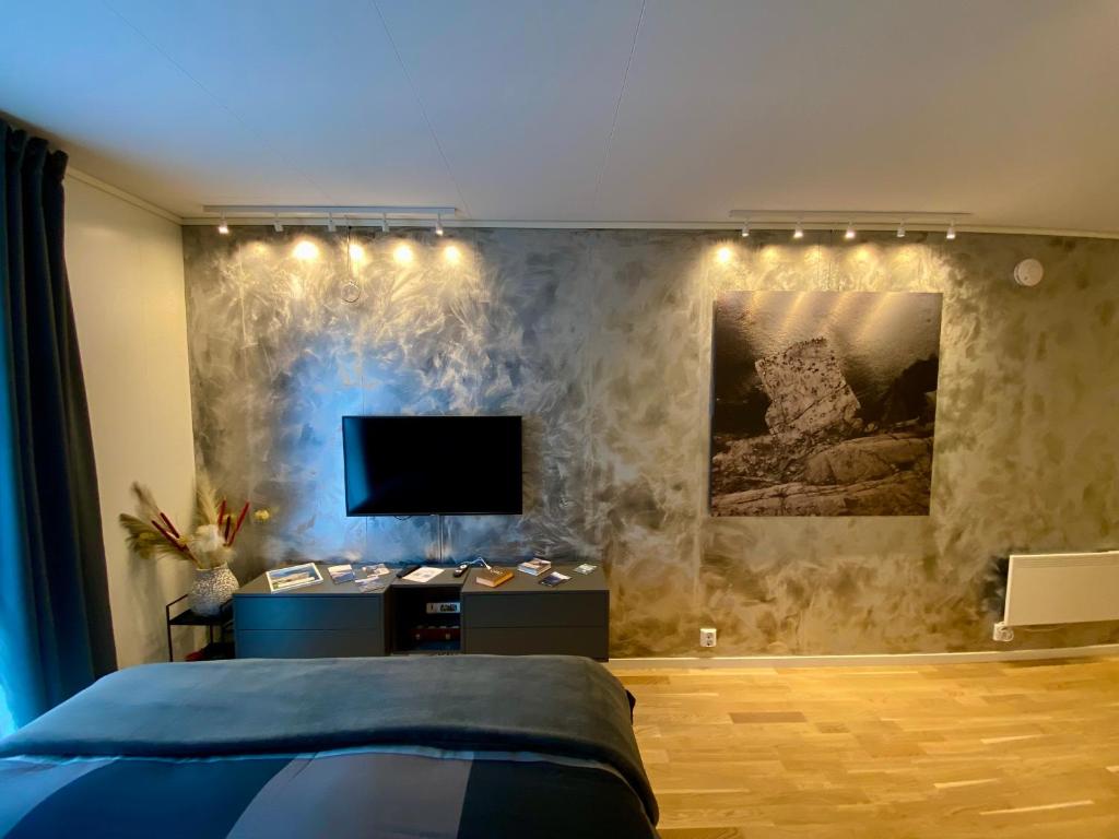 een slaapkamer met een bed en een flatscreen-tv bij Experience a Cozy Getaway Near Pulpit Rock in Strand