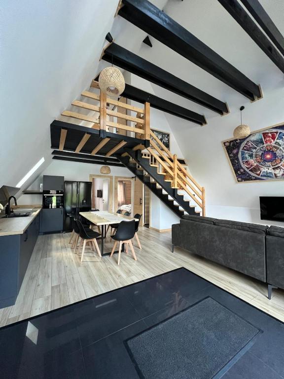 a kitchen and dining room with a spiral staircase at CabanA Oscar in Borşa