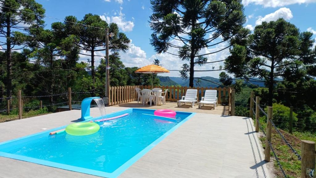 una piscina con un tobogán de agua en un patio trasero en Casa aconchegante em meio a natureza, en Caxias do Sul