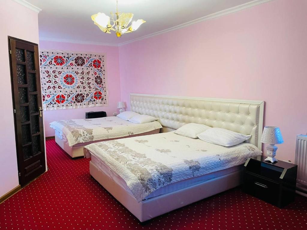 twee bedden in een kamer met roze muren bij Hello Uzbekistan! Chorminor Premium Est-Since 1826 Free Laundry for Walk in Guest Backpackers, Motorcycles in Bukhara